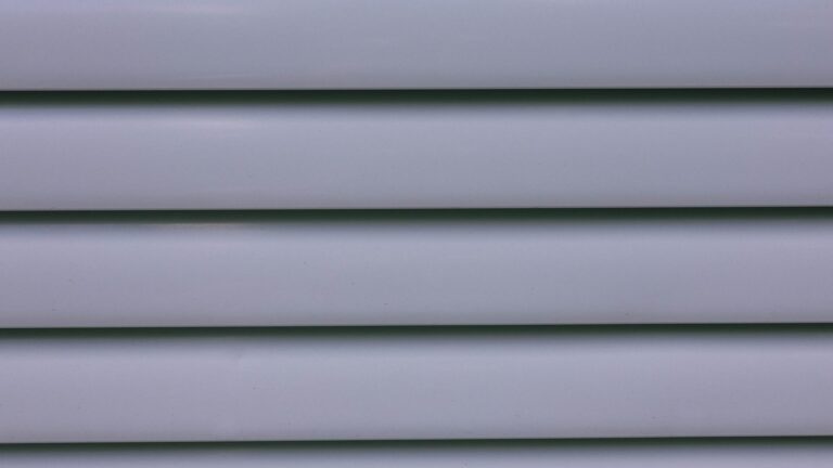 Close-up of light-gray horizontal vinyl lap siding on a house exterior