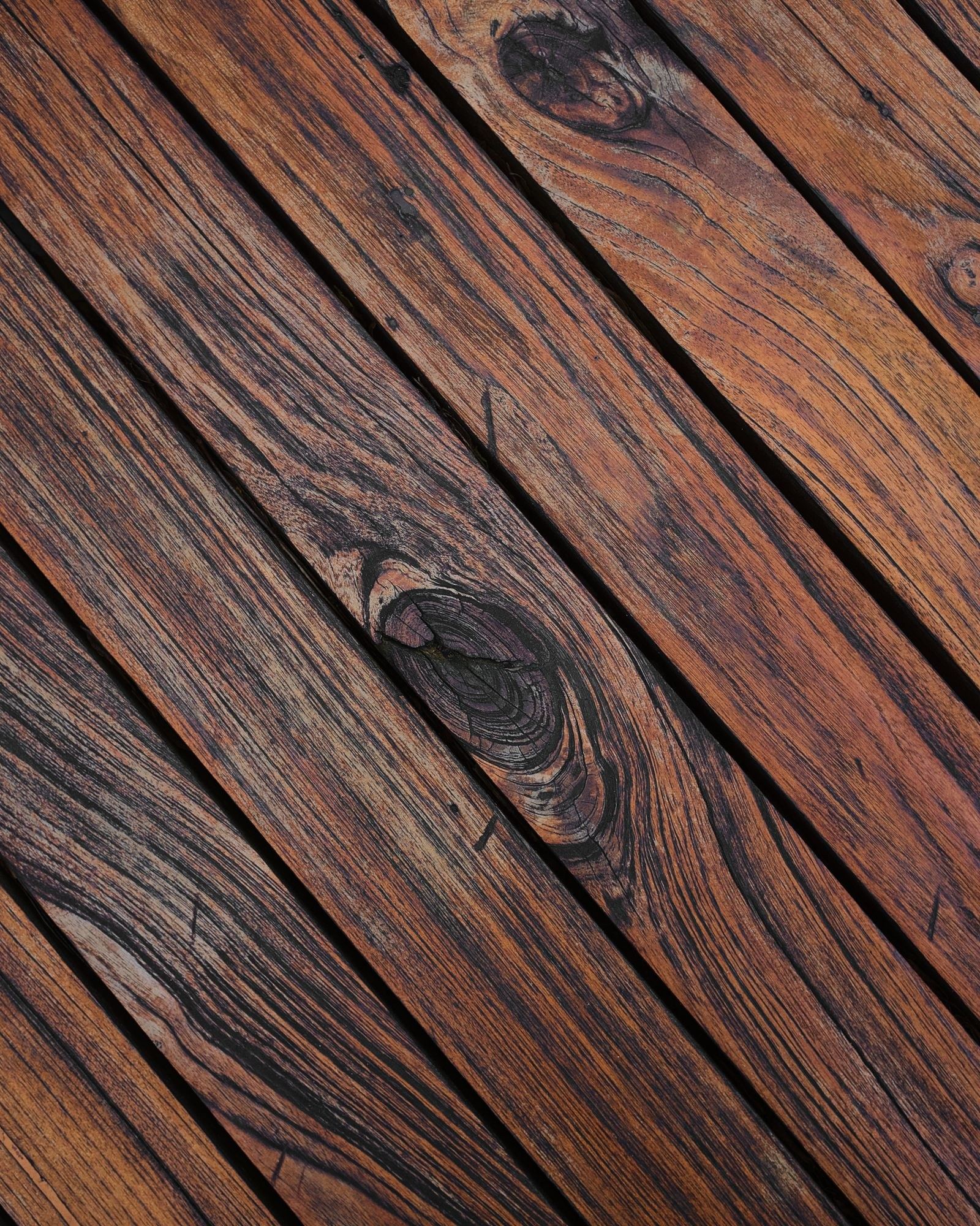 Close-up of weathered wooden deck boards showing gray grain and texture, the kind of buildup that raises a cleaning quote