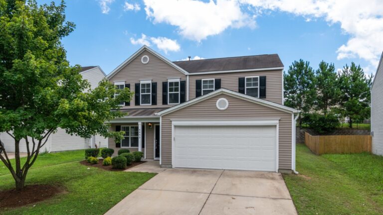 What Is Vinyl Siding? Types, Materials and How It Protects Your Home Two-story suburban home with vinyl siding under a blue sky