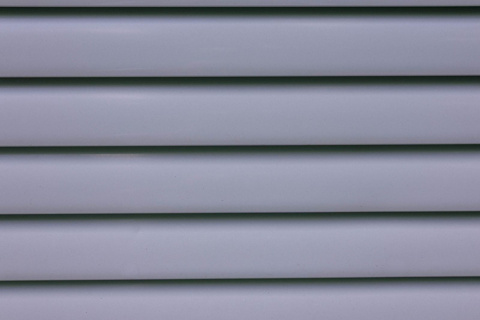 Close-up of vinyl siding panels showing the interlocking profile and embossing